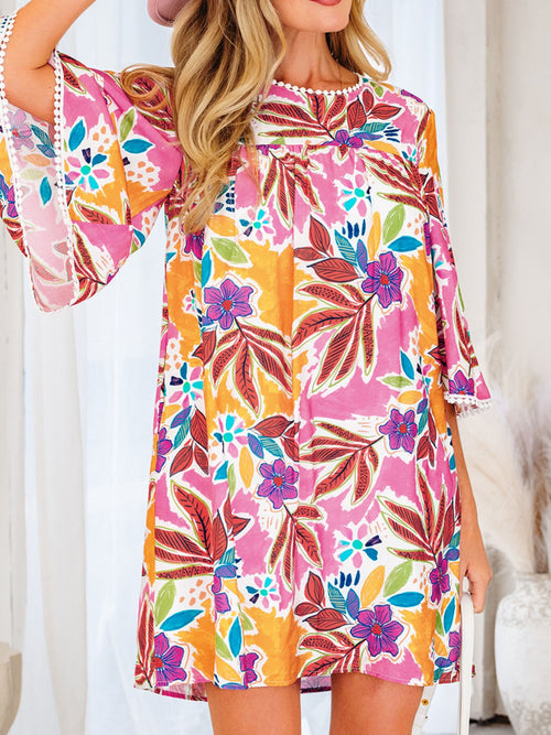 Model wearing the colorful floral mini dress with one arm raised