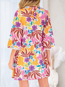 Back view of the floral mini dress with bell sleeves and lace-trim cuffs