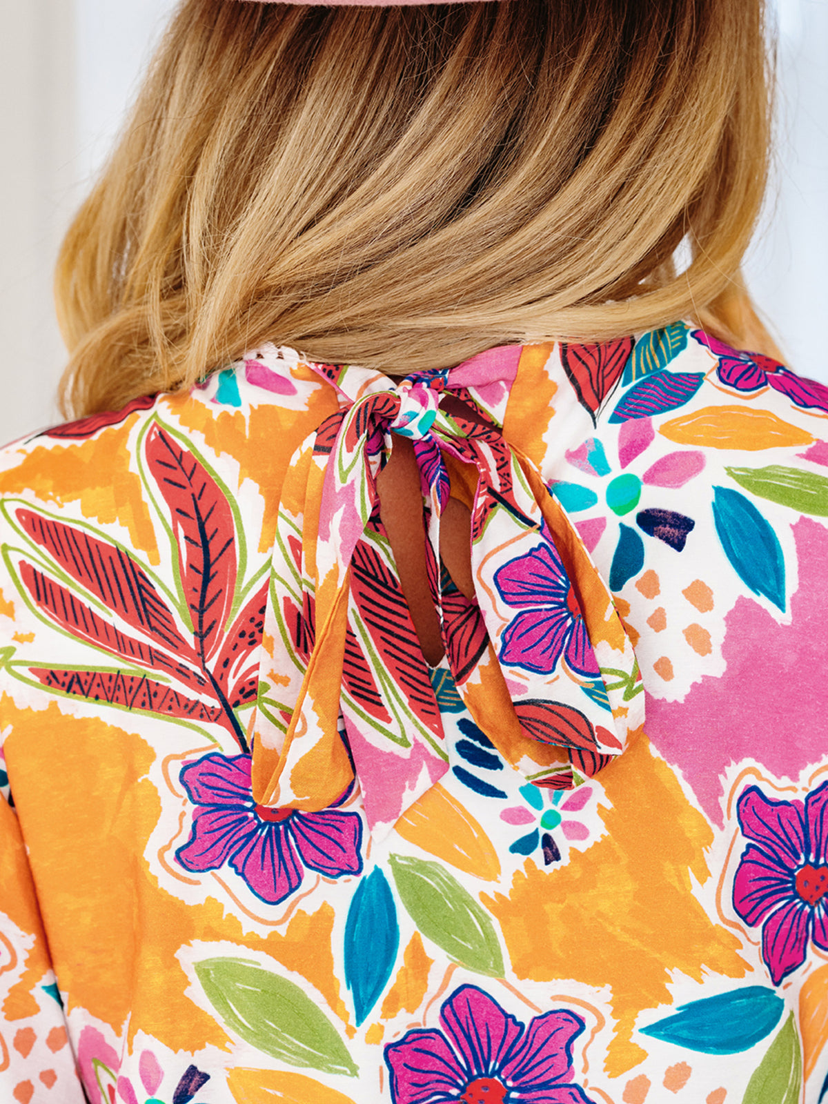Close-up of the dress tie-back neckline and keyhole opening on a model