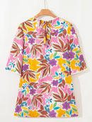 Back view of the floral mini dress on a hanger showing the tie neckline