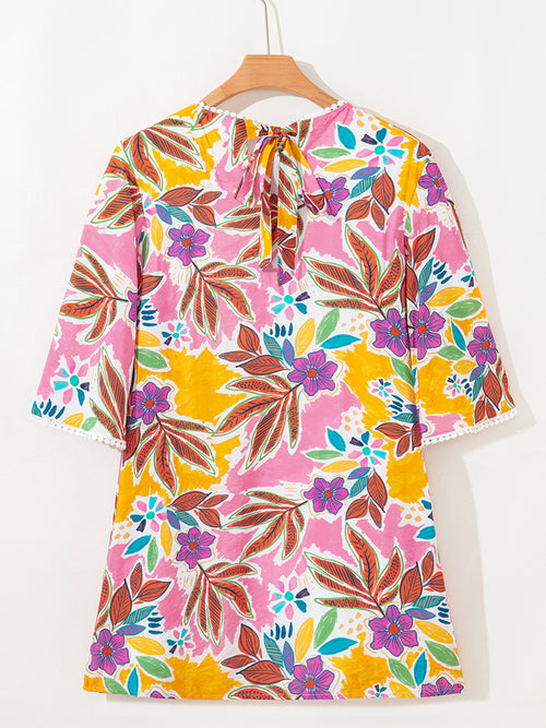 Back view of the floral mini dress on a hanger showing the tie neckline