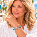 Styling photo of a woman in a white blouse wearing a bracelet with turquoise snap charms
