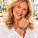Styling photo of a woman in a white blouse wearing a bracelet with blue and silver snap charms