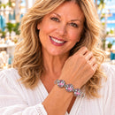 Styling photo of a woman in a white blouse wearing a bracelet with pink and silver snap charms