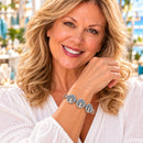 Styling photo of a woman in a white blouse wearing a bracelet with blue and silver snap charms