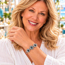 Styling photo of a woman in a white blouse wearing a bracelet with black and silver snap charms