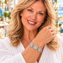 Styling photo of a woman in a white blouse wearing a bracelet with gold and silver snap charms