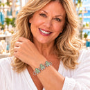 Styling photo of a woman in a white blouse wearing a bracelet with green snap charms