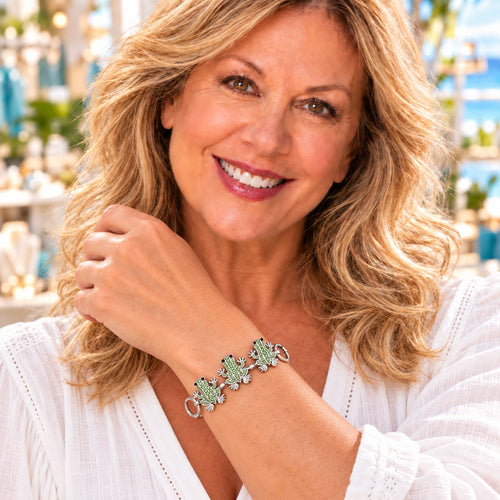 Styling photo of a woman in a white blouse wearing a bracelet with green snap charms