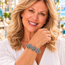 Styling photo of a woman in a white blouse wearing a bracelet with turquoise and pink snap charms