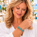 Styling photo of a woman in a white blouse wearing a bracelet with green and silver snap charms