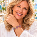 Styling photo of a woman in a white blouse wearing a bracelet with pink snap charms