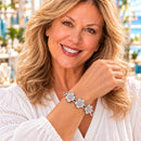Styling photo of a woman in a white blouse wearing a bracelet with iridescent snap charms