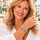 Styling photo of a woman in a white blouse wearing a bracelet with silver snap charms