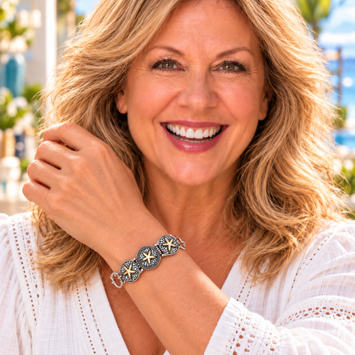 Styling photo of a woman in a white blouse wearing a bracelet with bronze snap charms