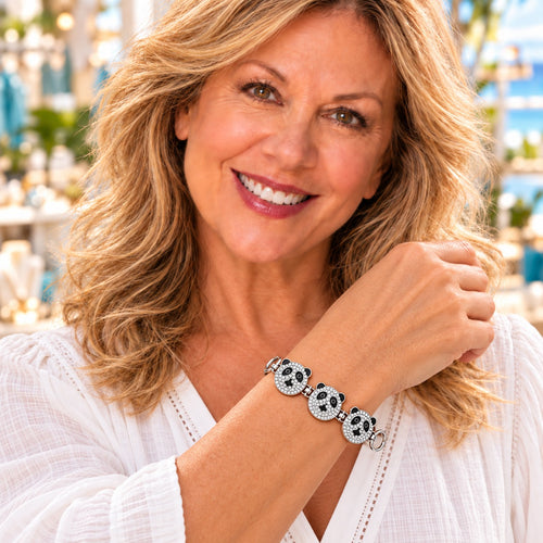 Styling photo of a woman in a white blouse wearing a bracelet with black and white snap charms