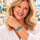 Styling photo of a woman in a white blouse wearing a bracelet with blue snap charms