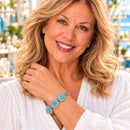 Styling photo of a woman in a white blouse wearing a bracelet with blue and clear snap charms