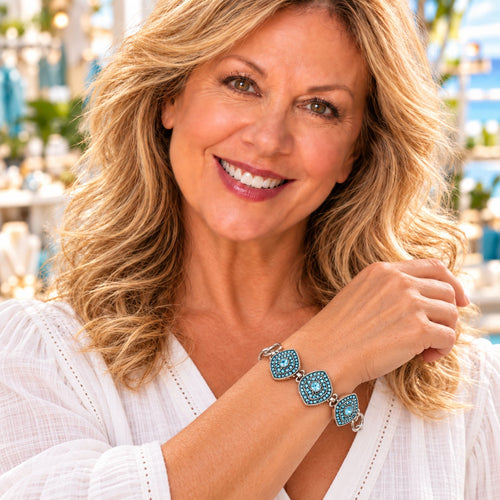 Styling photo of a woman in a white blouse wearing a bracelet with turquoise snap charms