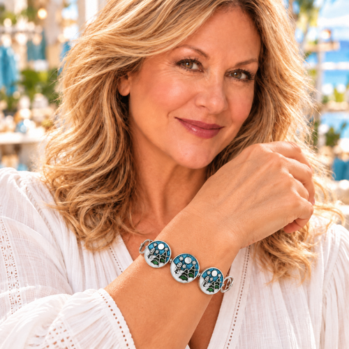 Styling photo of a woman in a white blouse wearing a bracelet with blue and silver snap charms