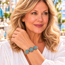 Styling photo of a woman in a white blouse wearing a bracelet with blue and green snap charms