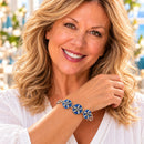Styling photo of a woman in a white blouse wearing a bracelet with blue snap charms