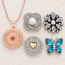 Plain rose gold Sandy Snap necklace with empty socket beside pearl, clear crystal, gold heart and blue butterfly snap choices