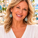 Woman wearing silver-tone drop earrings with turquoise charms