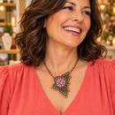 Model in coral blouse wearing antique bronze butterfly Sandy Snap necklace with pink crystal flower snap; styling example