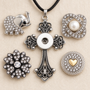 Empty Founders Favorite Cross necklace beside elephant, pearl, crystal flower and gold heart snap choices