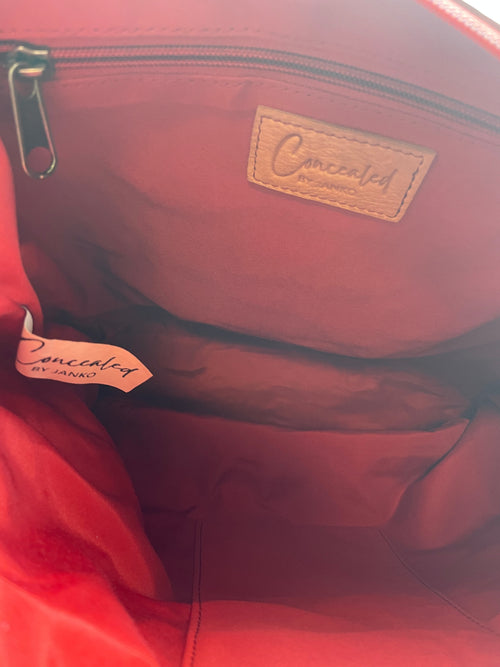 Interior of the Janko Ruth Wine handbag showing its red lining and pockets